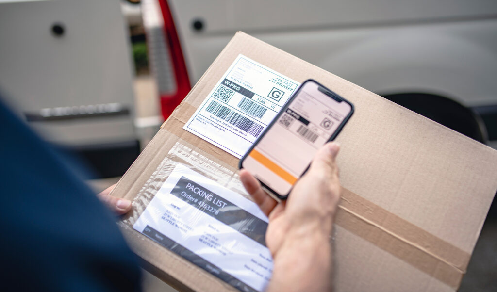 Man scanning barcode on shipping label on box